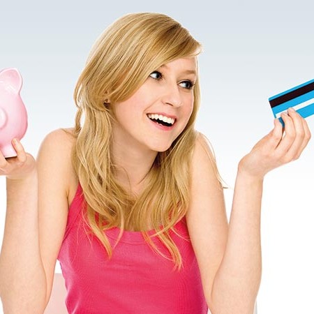 Young woman holding credit card and piggypank