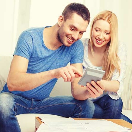 Young smiling couple with calculator and paperwork