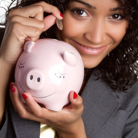 Happy woman putting cash in piggybank