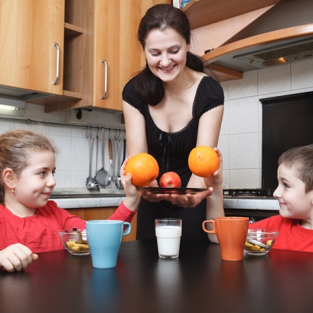 Mum in kitchen offering kids fruit