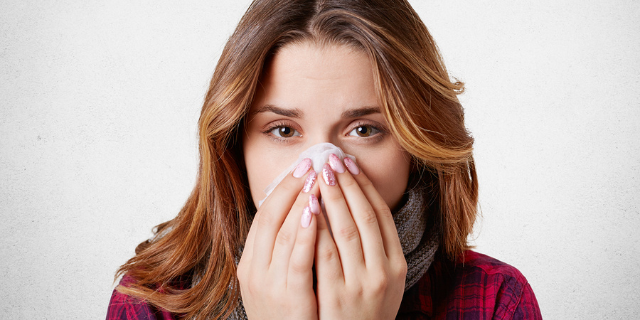 Close up portrait of beautiful woman sneezes and coughs