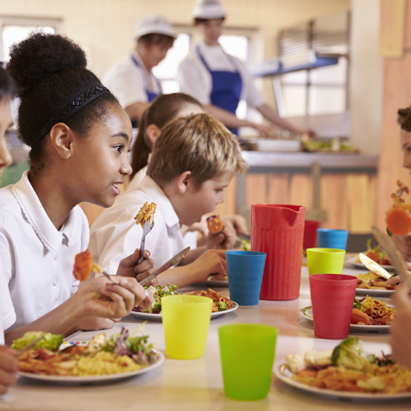 Primary school children eating lunch in school canteen
