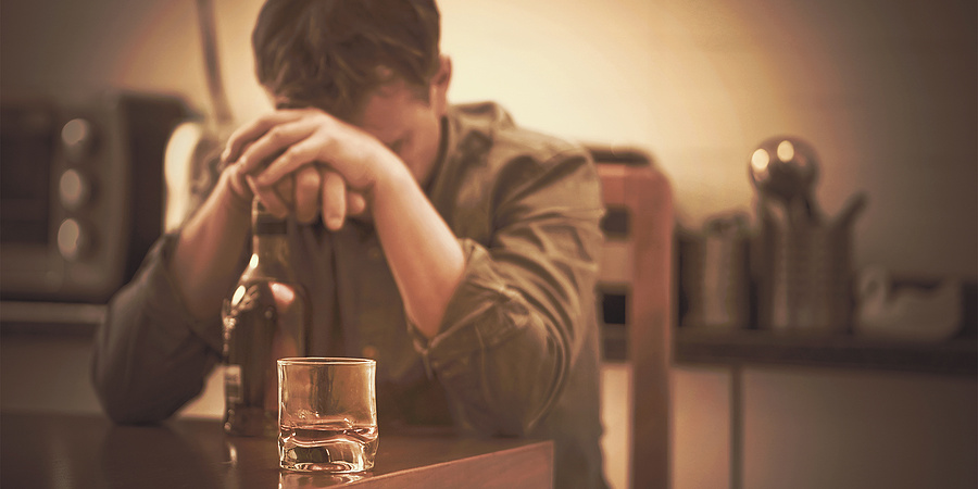 Unhappy man with bottle of whiskey