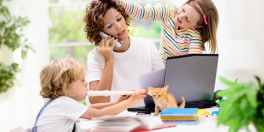 Woman working from home with her two small children