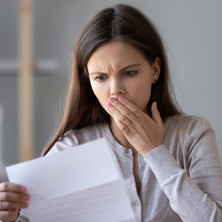 Shocked woman reading debt collection letter