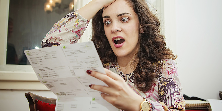 Shocked young woman looking at her council tax bill