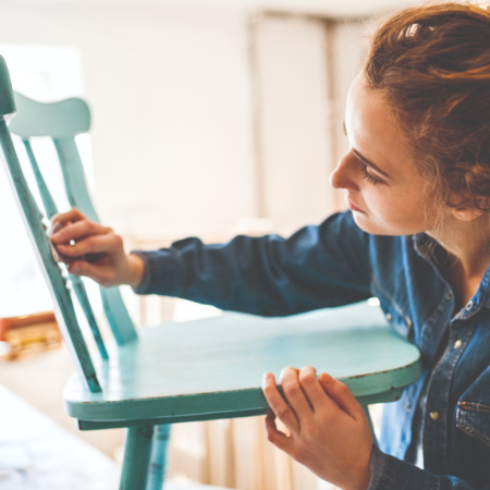 Woman renovating a wooden chair