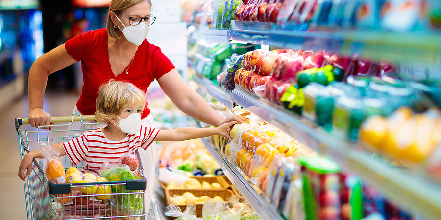Mum and young son in supermarket shopping for food