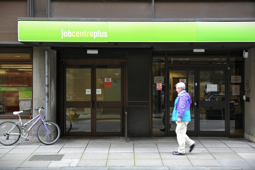 Older man walks past UK jobcentre