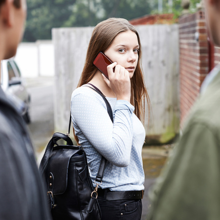 Young woman on mobile phone intimidated by loan sharks