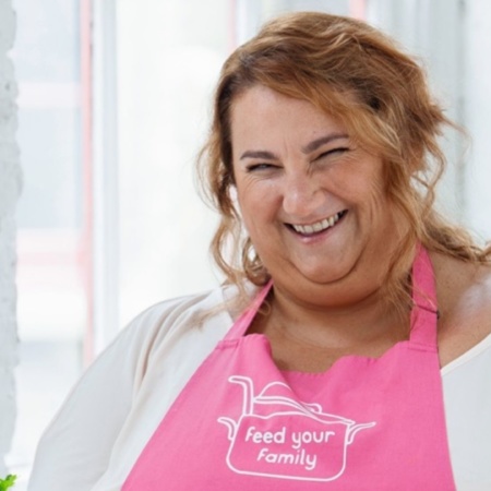 Lorna Cooper smiling in a pink apron