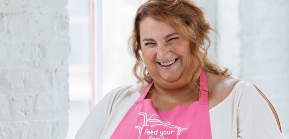 Lorna Cooper smiling in a pink apron
