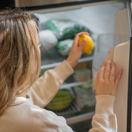 women putting food in her fridge