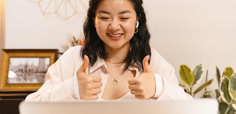 Woman giving thumbs up to her laptop
