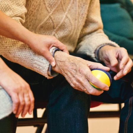 Carer holding the hand of an elderly patient