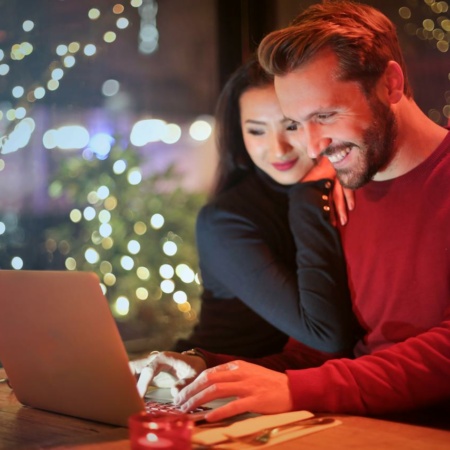 Happy couple looking at a laptop