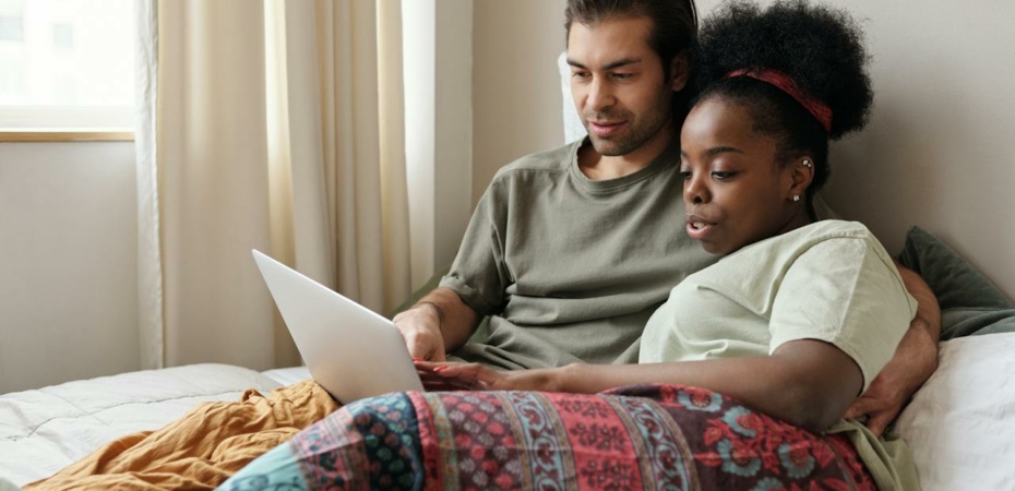 Cosy couple looking at a laptop