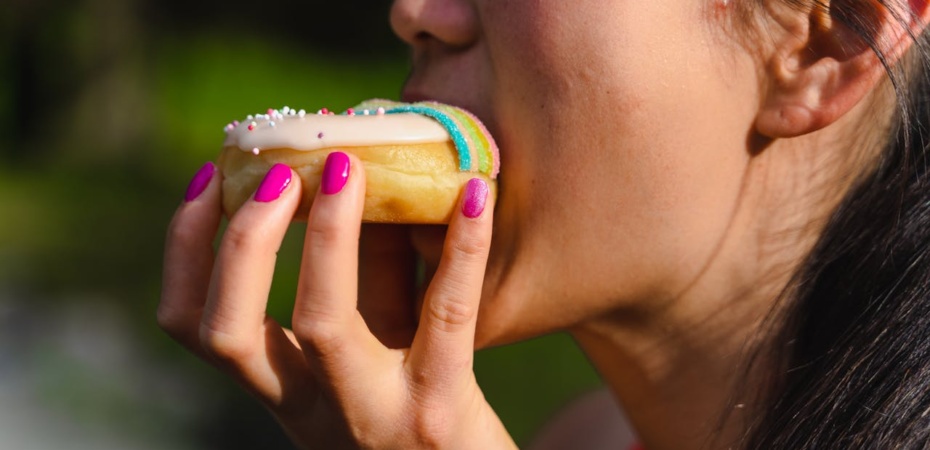 Woman biting into a doughnut